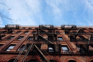 looking up at an apartment building with fire excapes